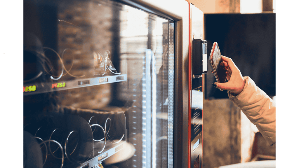 Staff retrieving items from a modern workplace vending machine in a Malaysian office