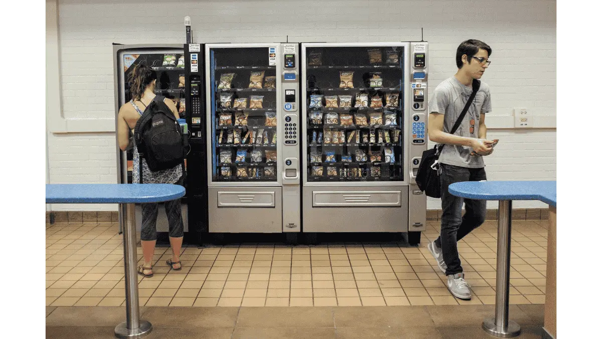 Student grabbing snack from school vending machine